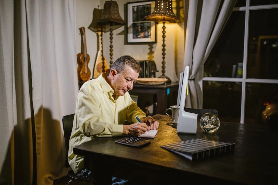 Eine Person schreibt strategische Notizen in ein Notizbuch in einem hellen, modernen Raum.